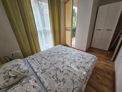 a bedroom with a bed and a large window at Релакс в Равда! in Ravda