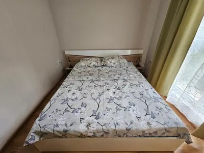 a bedroom with a bed with a blue and white comforter at Релакс в Равда! in Ravda