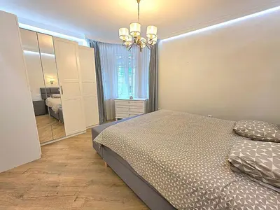 a bedroom with a bed and a dresser and a mirror at Seaside Apartment in Varna City