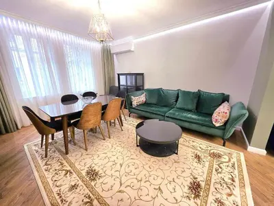 a living room with a green couch and a table at Seaside Apartment in Varna City