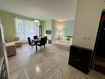 a living room with a bed and a dining room at Green apartments in Primorsko