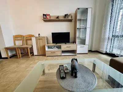 a cat statue sitting on a glass table in a living room at Green apartments in Primorsko