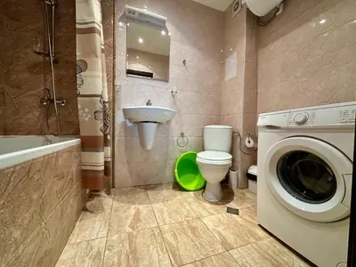 a bathroom with a washing machine and a toilet and a sink at Green apartments in Primorsko