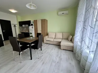 a living room with a table and a couch at Green apartments in Primorsko