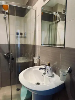 a bathroom with a sink and a glass shower at Green apartments in Primorsko