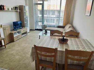 a living room with a table and a couch at Green apartments in Primorsko