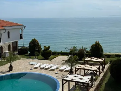 a pool with chairs and a view of the ocean at Sun Coast by the Sea in Sveti Vlas