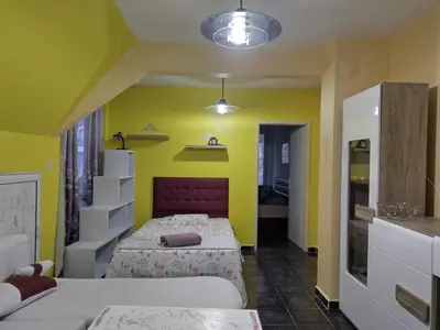 a bedroom with two beds and a yellow wall at Pomponi in Burgas City