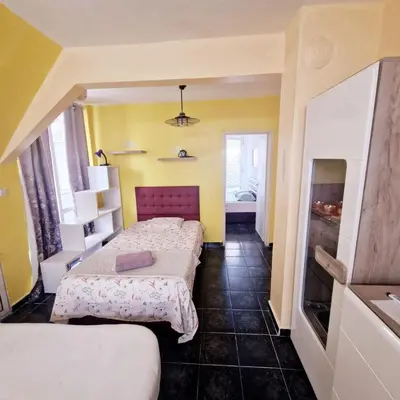 a hotel room with two beds and a tv at Pomponi in Burgas City