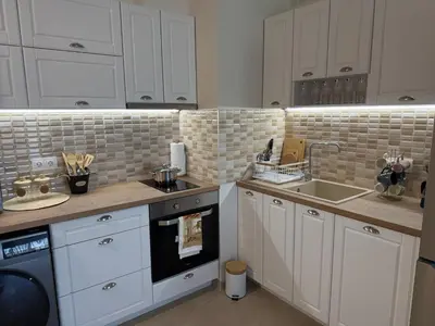 a kitchen with white cabinets and a sink at Апартаменти Sozopol Residence in Sozopol
