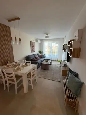 a living room with a table and a couch at Апартаменти Sozopol Residence in Sozopol
