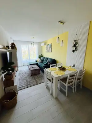 a living room with a table and a couch at Апартаменти Sozopol Residence in Sozopol