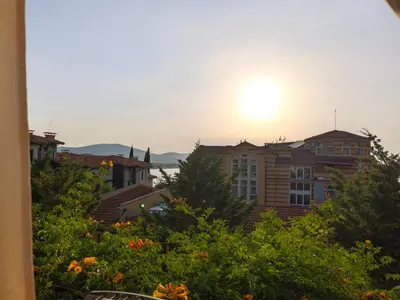 a view of the sun setting behind some buildings at Lavender Apartment in Sozopol