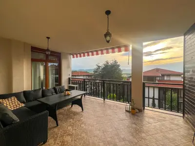 a living room with a couch and a table on a balcony at Lavender Apartment in Sozopol