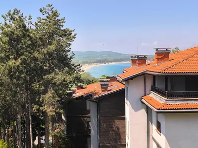 a building with orange roofs and a view of a beach at Lavender Apartment in Sozopol