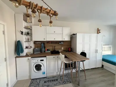 a kitchen with a washing machine and a table at Casa del Sol in Sunny Beach