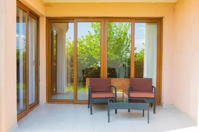 a porch with two chairs and a table and windows at 