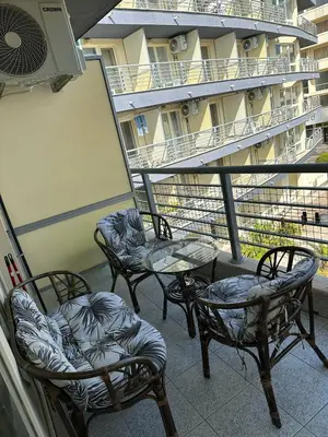 three chairs and a table on the balcony of a building at Nana Studio Sunny Beach in Sunny Beach