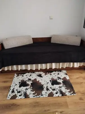 a bedroom with a bed with a rug on the floor at Kasndra in Byala