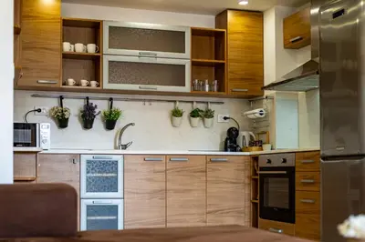 a kitchen with wooden cabinets and potted plants on the wall at Sunny apartment in the center of Varna for 5Guests in Varna City