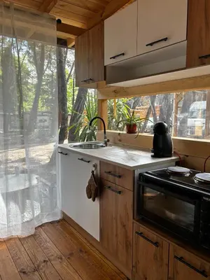 a kitchen with a sink and a stove and a window at Нереида in Sozopol