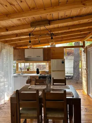 a kitchen with a wooden ceiling and a table with chairs at Нереида in Sozopol