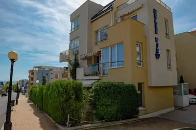 a yellow building on the side of a street at Belle View - Menada Apartments in Sveti Vlas