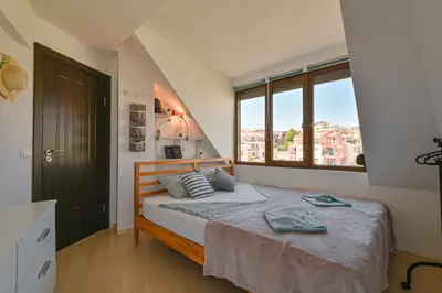 a bedroom with a bed and a large window at Via Sunride - Twin Maisonette Apartments by the sea in Sozopol
