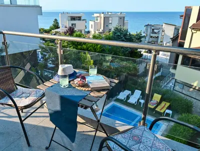 a table on a balcony with a view of the ocean at Via Sunride - Twin Maisonette Apartments by the sea in Sozopol