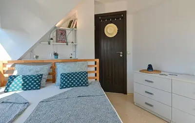 a bedroom with a bed with blue pillows and a door at Via Sunride - Twin Maisonette Apartments by the sea in Sozopol