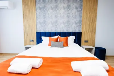 a bedroom with a large bed with orange pillows at Boulevard Hotel in Aytos
