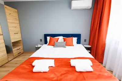 a bedroom with a large bed with orange pillows at Boulevard Hotel in Aytos