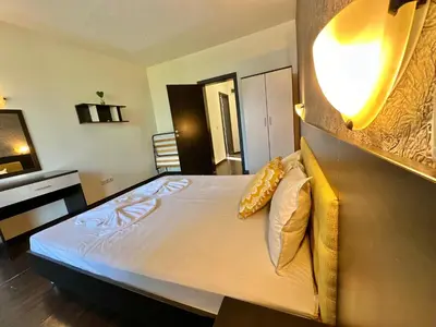 a bedroom with a bed with a light on the wall at Menada Imperial Heights Apartments in Sunny Beach