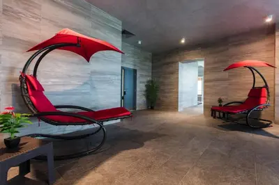 a room with two red chairs with umbrellas at Sea View Apartments Residence Лазурен бряг in Burgas City