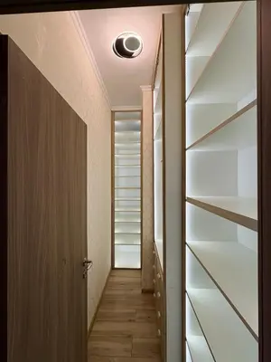 a hallway with wooden floors and a door and shelves at Sea View Apartments Residence Лазурен бряг in Burgas City