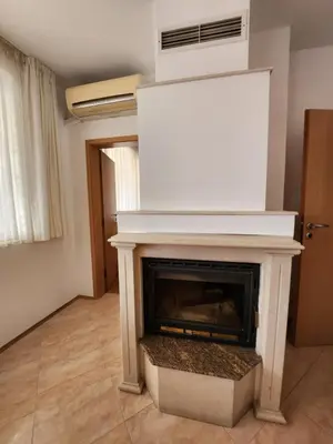 a living room with a fireplace with a white mantle at Лукс Апартамент Лазур с безплатен паркинг in Pomorie