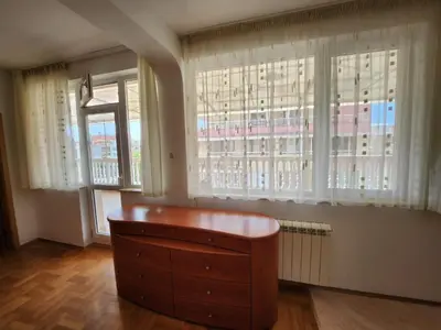 a room with a dresser and two large windows at Лукс Апартамент Лазур с безплатен паркинг in Pomorie