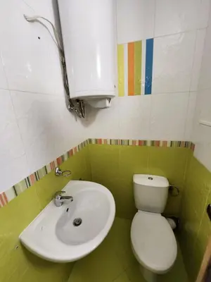 a bathroom with a white toilet and a sink at Лукс Апартамент Лазур с безплатен паркинг in Pomorie