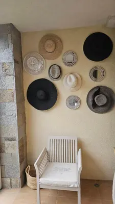 a room with a white bench and some hats on the wall at Vladan apartments in Sozopol