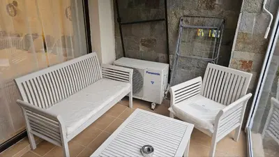 three white chairs and a bench on a porch at Vladan apartments in Sozopol