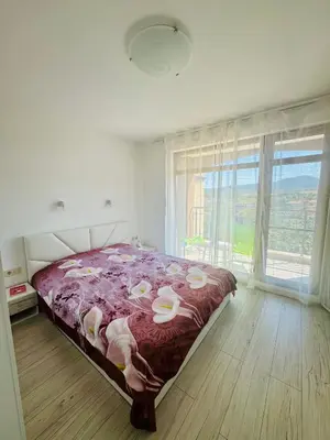 a bedroom with a bed and a large window at Елскер in Tsarevo