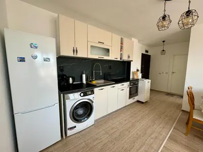 a kitchen with a washing machine and a refrigerator at Елскер in Tsarevo