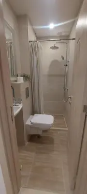 a small bathroom with a toilet and a shower at Condo Santosha on the beach in Pomorie