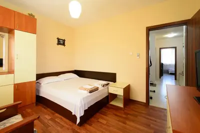 a small bedroom with a bed and a mirror at Apartment Yanevi in Lozenets
