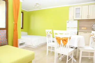 a kitchen with a table and chairs in a room at Flora Deluxe Studio in Burgas City