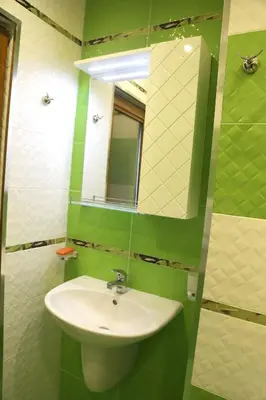 a green and white bathroom with a sink and mirror at Flora Deluxe Studio in Burgas City