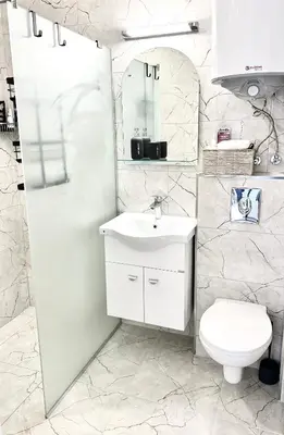 a white bathroom with a sink and a toilet at Polarstar Apartment in Sveti Vlas