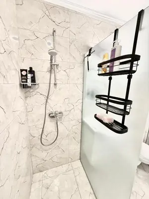 a white bathroom with a shower and a sink at Polarstar Apartment in Sveti Vlas