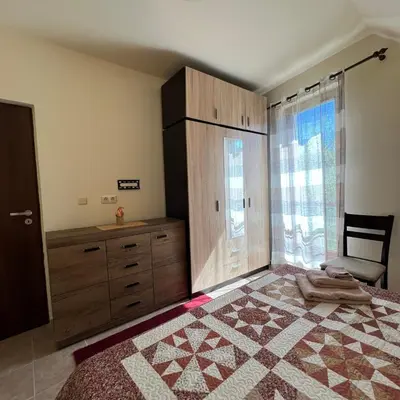 a bedroom with a bed and a dresser and a window at Морска Идилия in Burgas City