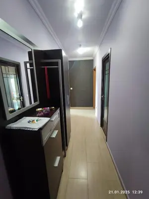 a hallway of a bathroom with a sink and a mirror at Central View Burgas in Burgas City